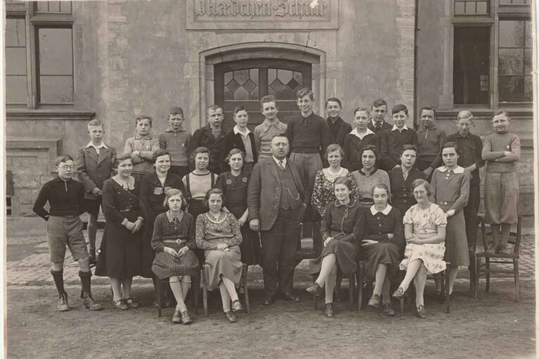 Schulbild 1938 mit Lehrer Johann Fries vor der alten Schule im Wilhelm-Spies-Haus.