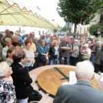 Besucher der Feier hören sich den Bericht von Dr. Kurz an