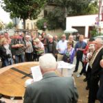 Besucher der Feier hören sich den Bericht von Dr. Kurz an